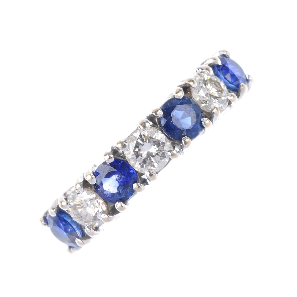 An 18ct gold sapphire and diamond band ring. The alternating brilliant-cut diamond and circular-