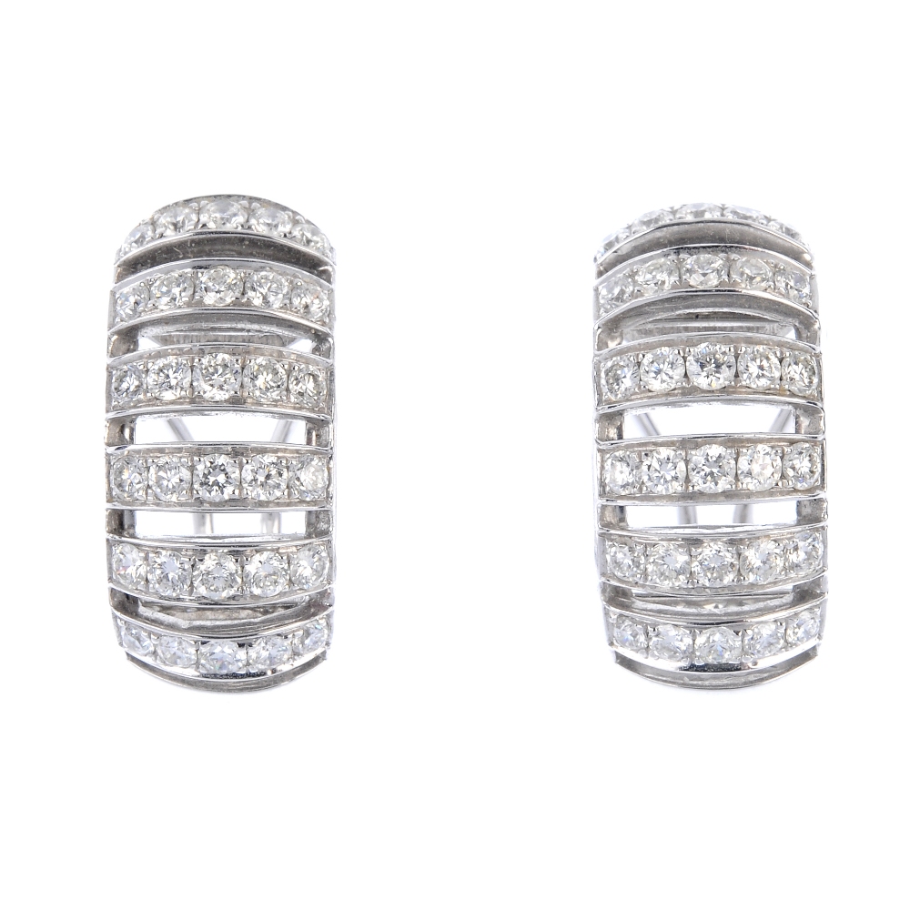 A pair of diamond earrings. Each designed as a series of brilliant-cut diamond curved lines.