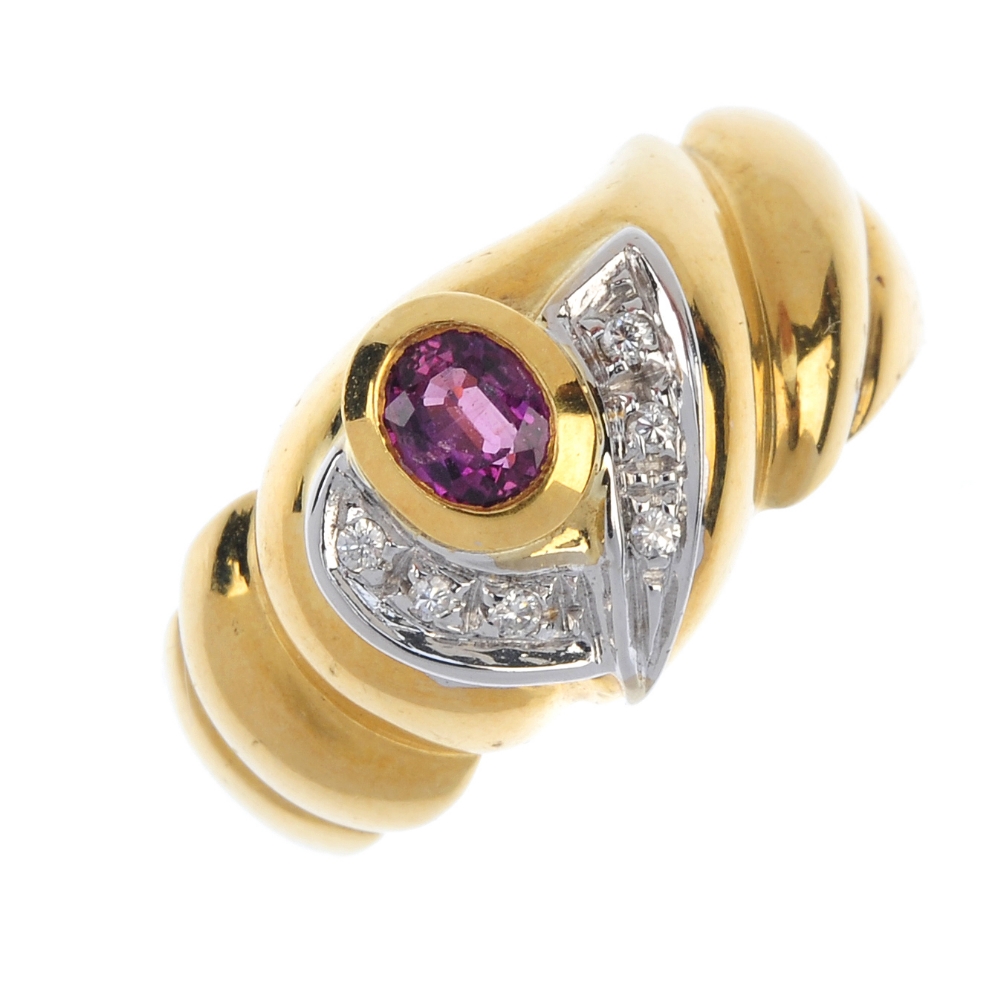 An 18ct gold ruby and diamond dress ring. The oval-shape ruby collet, with crossover brilliant-cut