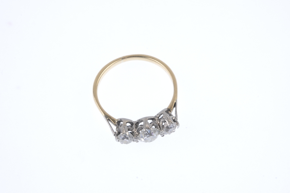 A diamond three-stone ring. The old-cut diamond, with similarly-cut diamond sides, to the plain - Image 2 of 4