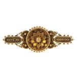 A late 19th century gold brooch. The floral centre, within a cannetille surround, to the similarly-