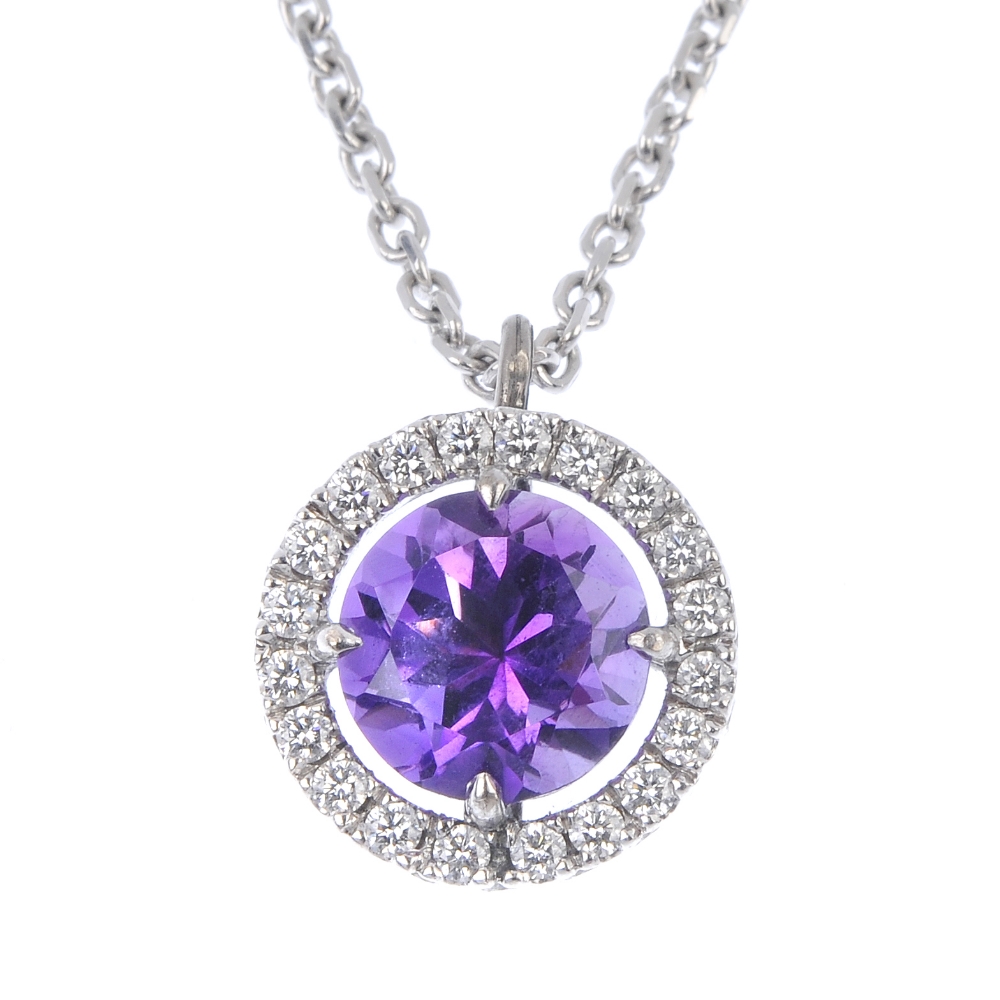 An amethyst and diamond cluster pendant. The circular-shape amethyst, within a brilliant-cut diamond