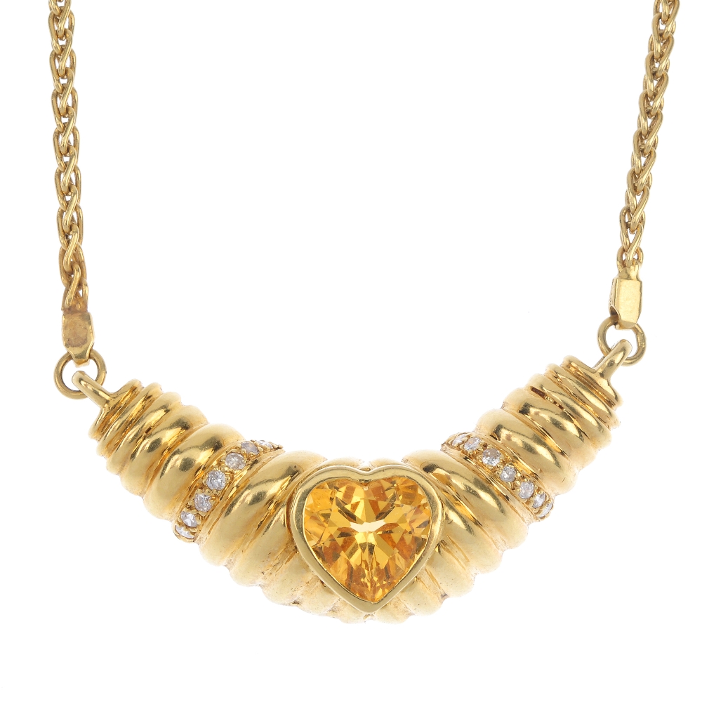 A citrine and diamond necklace.The heart-shape citrine collet, inset to the grooved chevron panel,