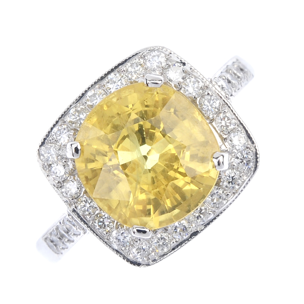 A sapphire and diamond dress ring. The cushion-shape yellow sapphire, with brilliant-cut diamond
