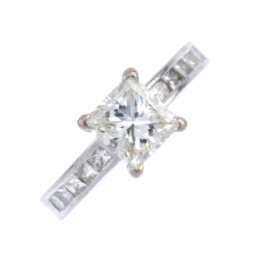 An 18ct gold diamond single-stone ring. The square-shape diamond, between similarly-cut diamond