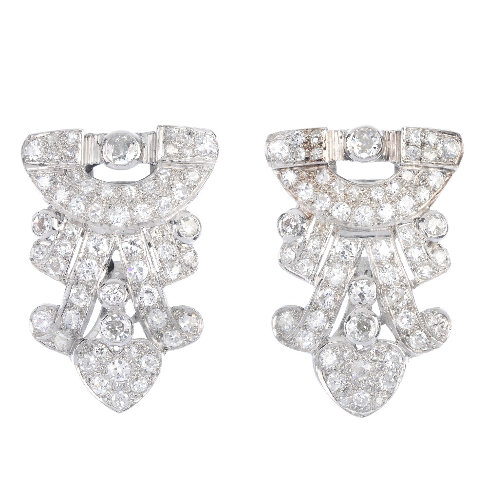 A pair of mid 20th century diamond clip brooches. Of openwork design, the geometric panels, set