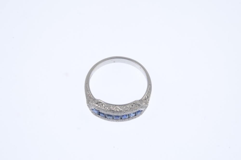 A sapphire and diamond dress ring. The calibre-cut sapphire line, within a brilliant-cut diamond - Image 2 of 4