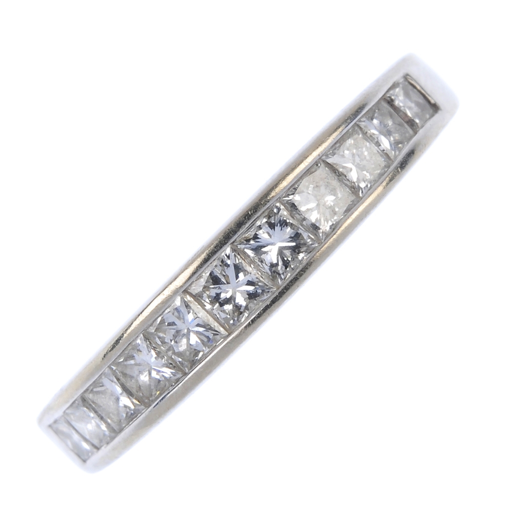 A diamond band ring. The graduated square-shape diamond line, within a channel setting, to the