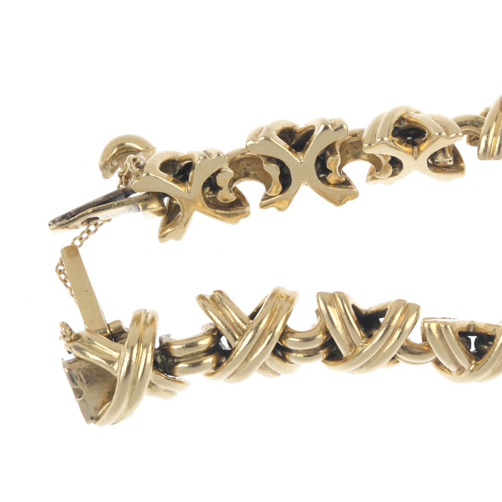 TIFFANY & CO. - a 'Kisses' bracelet. Designed as a series of crossed bars, interspaced by grooved - Image 3 of 3