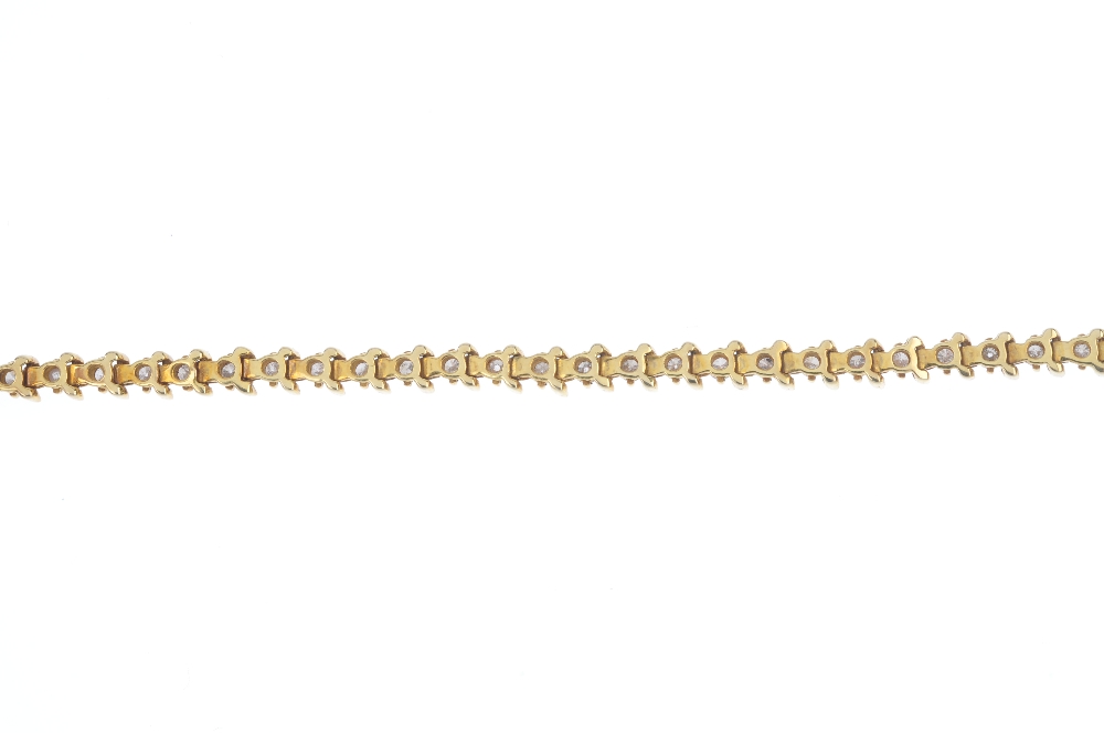 A diamond line bracelet. Designed as a series of brilliant-cut diamonds, with scrolling bar spacers, - Image 2 of 3