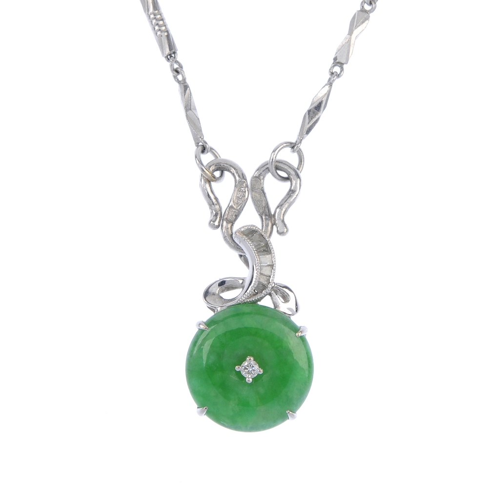 A jade and diamond pendant. The jadeite disc with brilliant-cut diamond highlight, suspended from