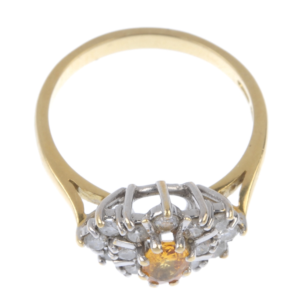 An 18ct gold sapphire and diamond cluster ring. The oval-shape orange sapphire, within an - Image 2 of 4