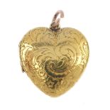 An early 20th century gold heart locket. The scroll engraved front panel, opening to reveal a