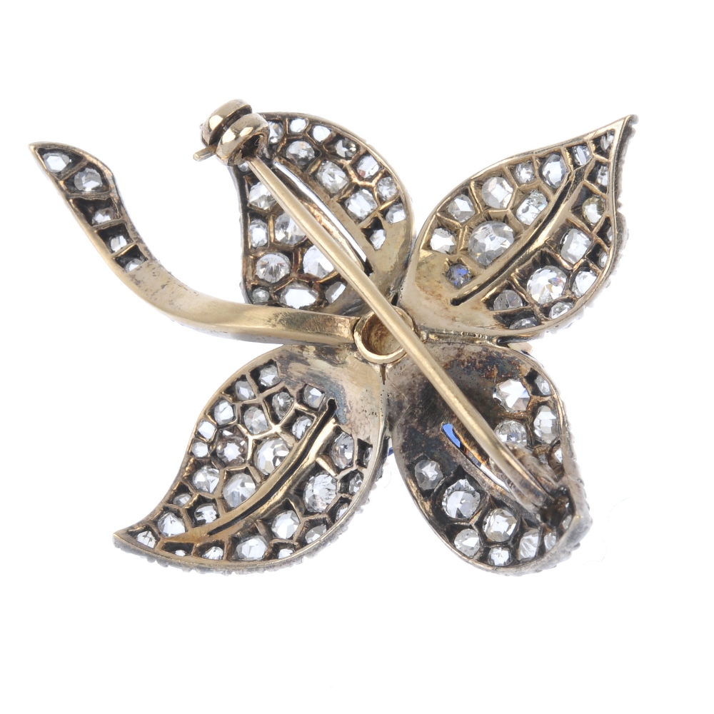 An early 20th century gold diamond and sapphire floral brooch. The old-cut diamond, within a pear- - Image 2 of 2