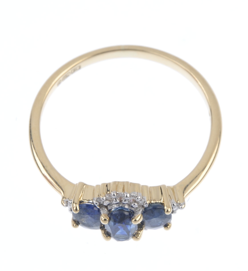 An 18ct gold sapphire and diamond three-stone ring. The slightly graduated oval-shape sapphire line, - Image 2 of 4