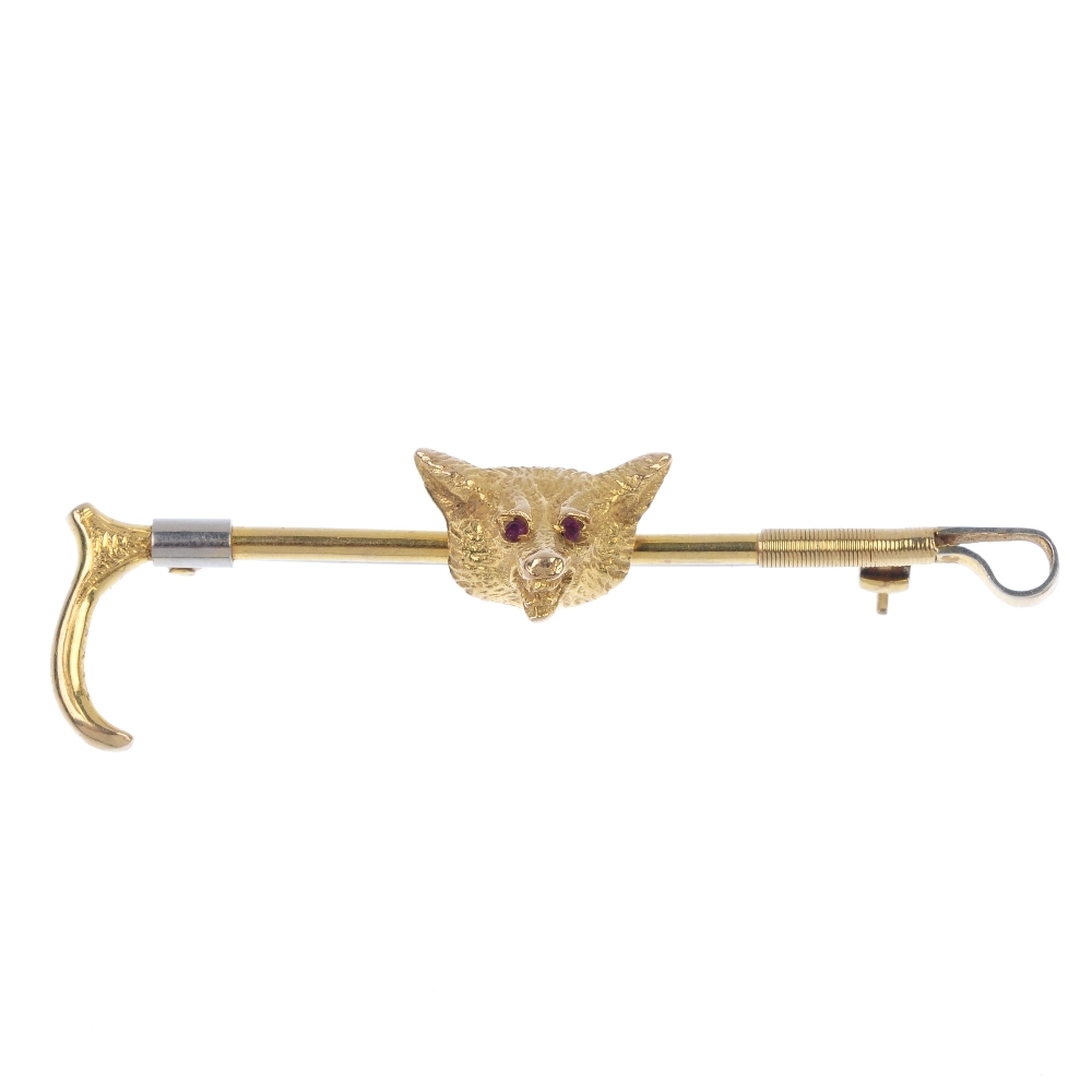 A mid 20th century 9ct gold ruby hunting brooch. The textured fox head, with ruby eye accents, to