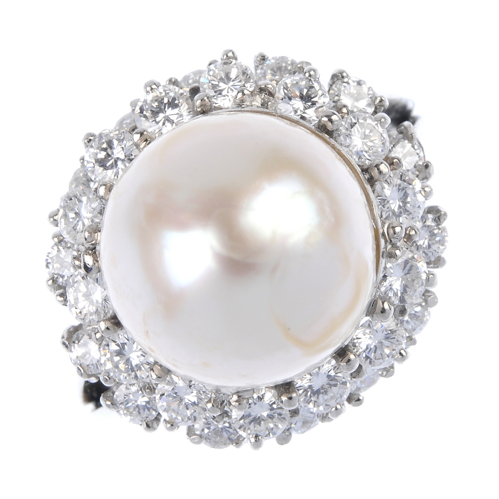 A cultured pearl and diamond cluster ring. The cultured pearl, measuring 20mms, within a brilliant-