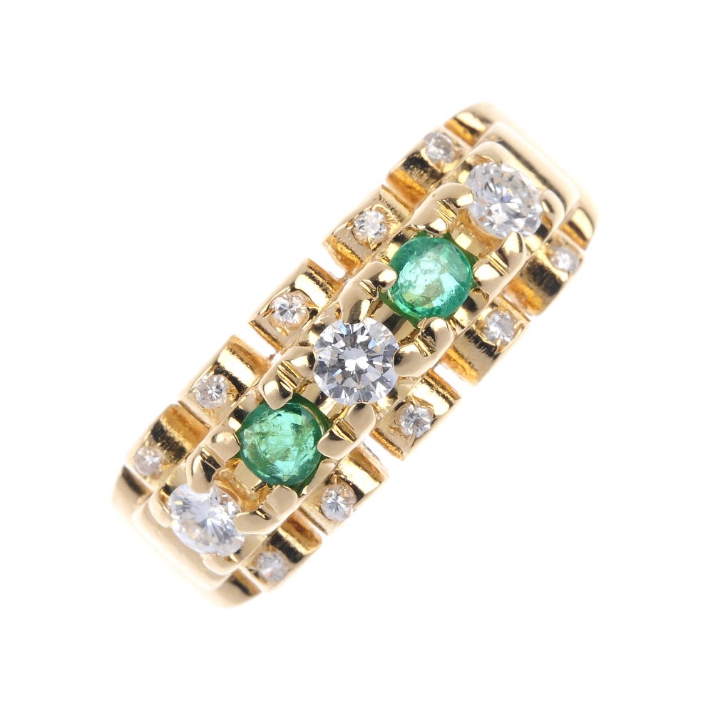 An 18ct gold emerald and diamond dress ring. The alternating brilliant-cut diamond and circular-