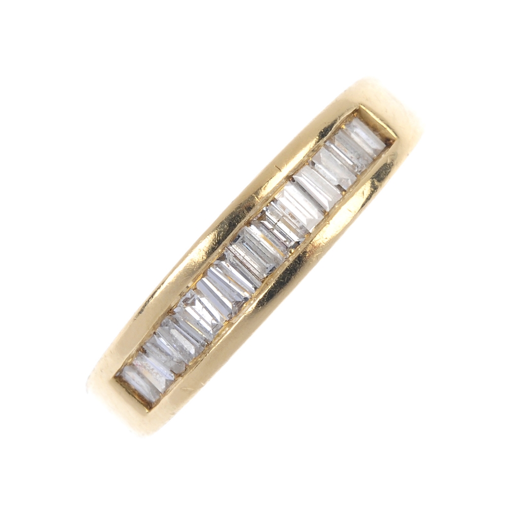 An 18ct gold diamond half-circle eternity ring. The baguette-cut diamond line, inset to the