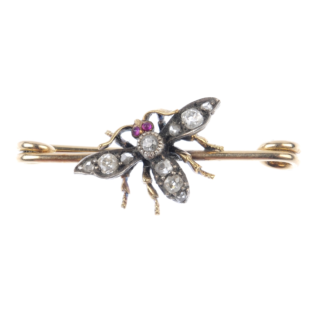 A diamond and ruby insect brooch. The old and rose-cut diamond body and wings, with ruby cabochon