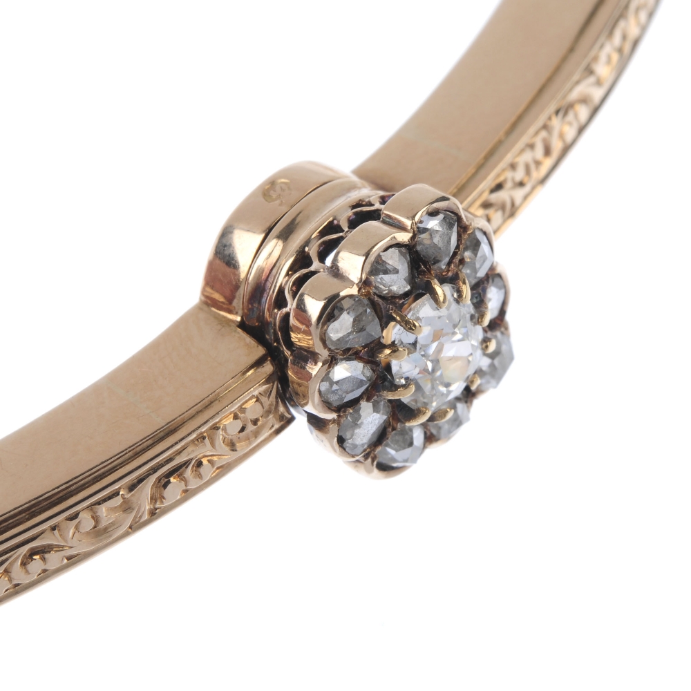 An early 20th century gold diamond hinged bangle. The old-cut diamond, within a rose-cut diamond - Image 2 of 3