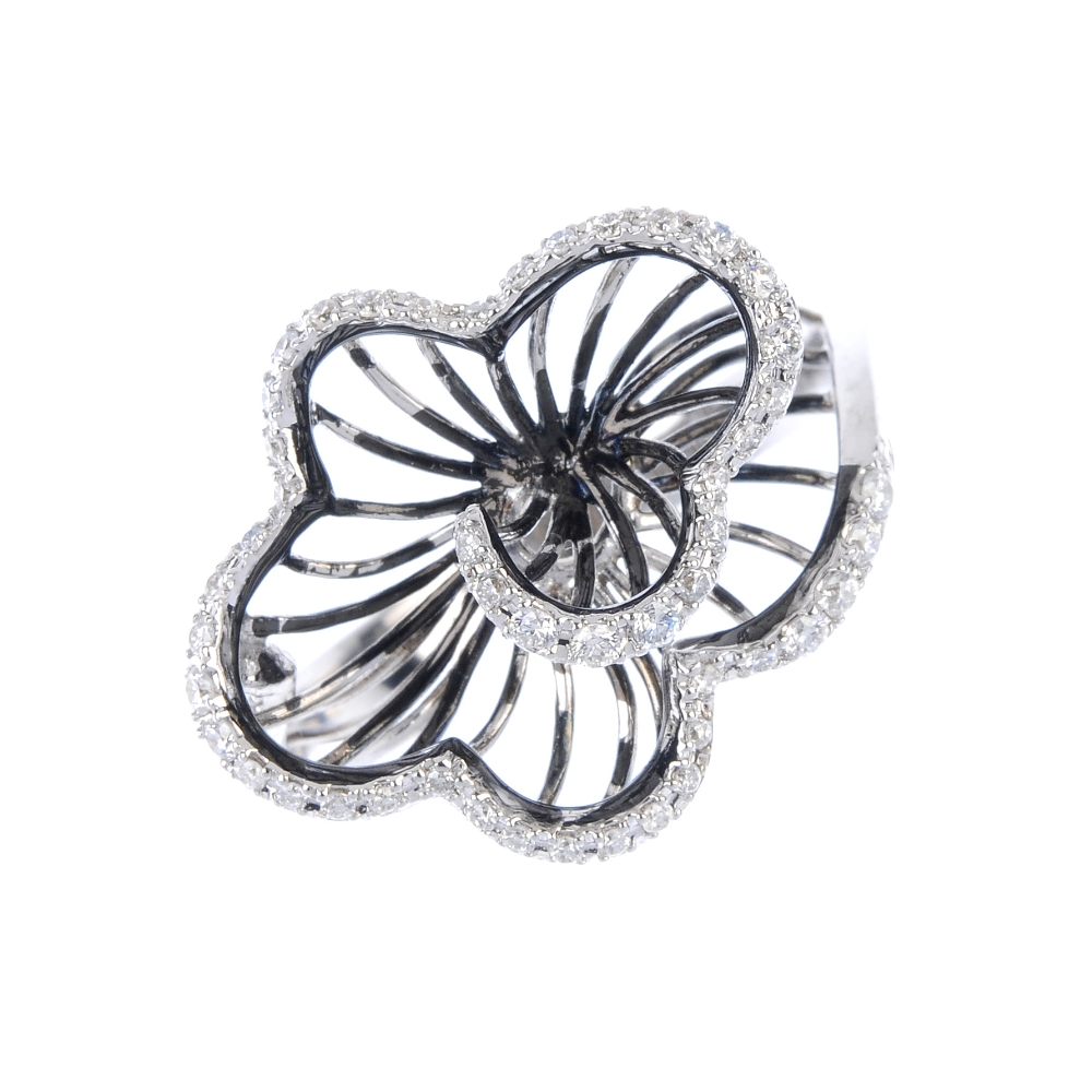 An 18ct gold diamond floral ring. Of wirework design, the graduated brilliant-cut diamond