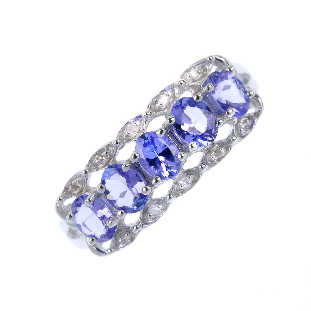 An 18ct gold tanzanite and diamond ring. The oval-shape tanzanite line, to the single-cut diamond