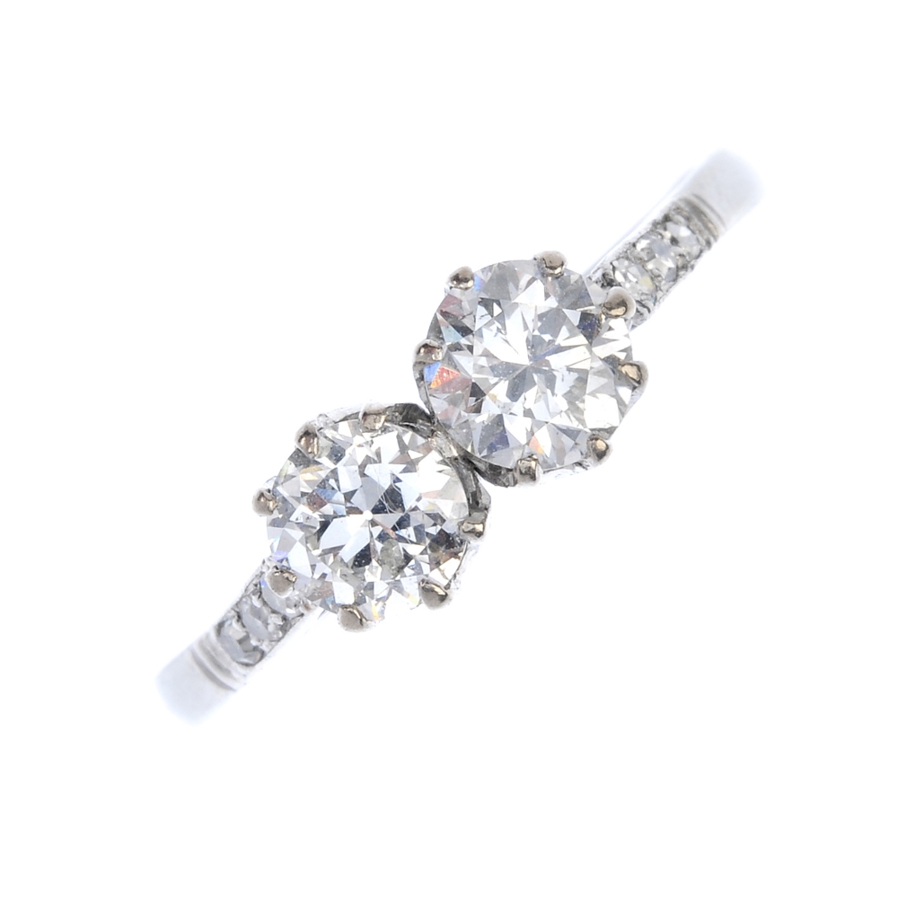 A diamond two-stone ring. The circular-cut diamond duo, with single-cut diamond line sides, to the