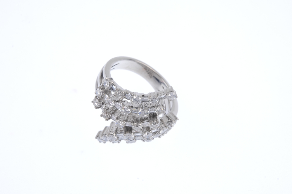 A diamond crossover ring. Comprising a stepped series of alternating brilliant and baguette-cut - Image 2 of 4