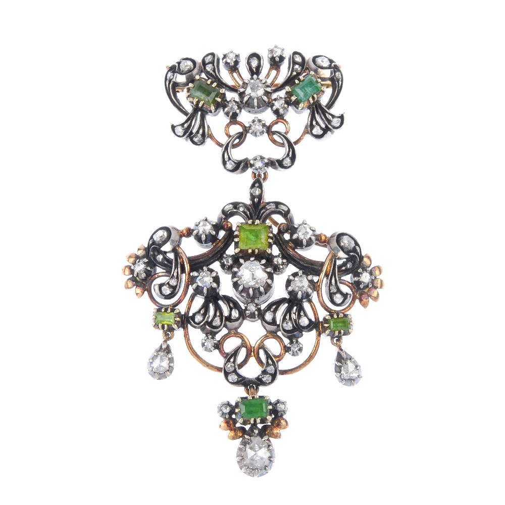 A foil-back diamond and emerald brooch. Of openwork design, the foil-back diamond and emerald