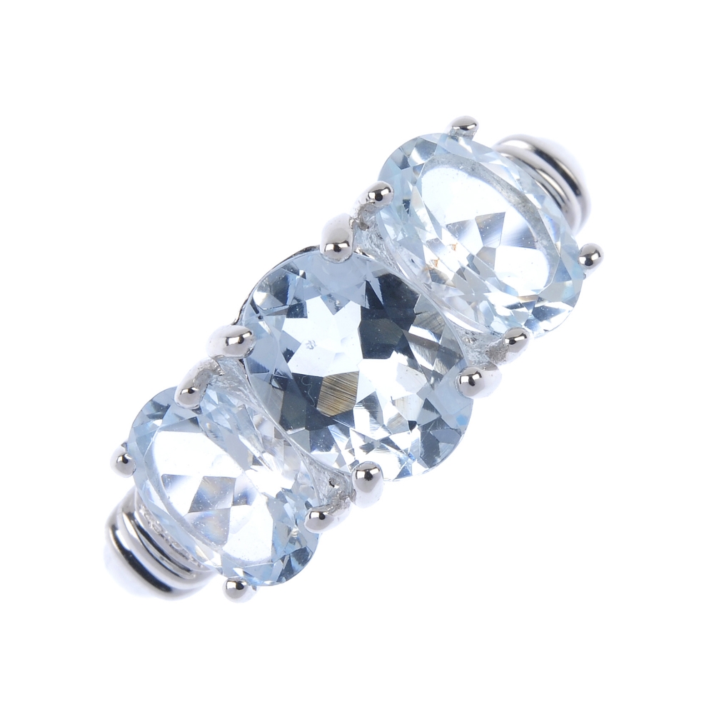 An 18ct gold aquamarine and diamond ring. The oval-shape aquamarine line, with single-cut diamond