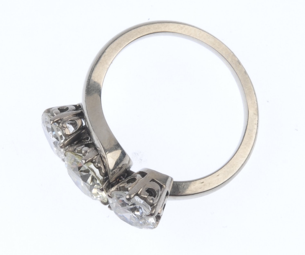 A diamond three-stone crossover ring. The graduated circular-shape diamond line, to the asymmetric - Image 2 of 3