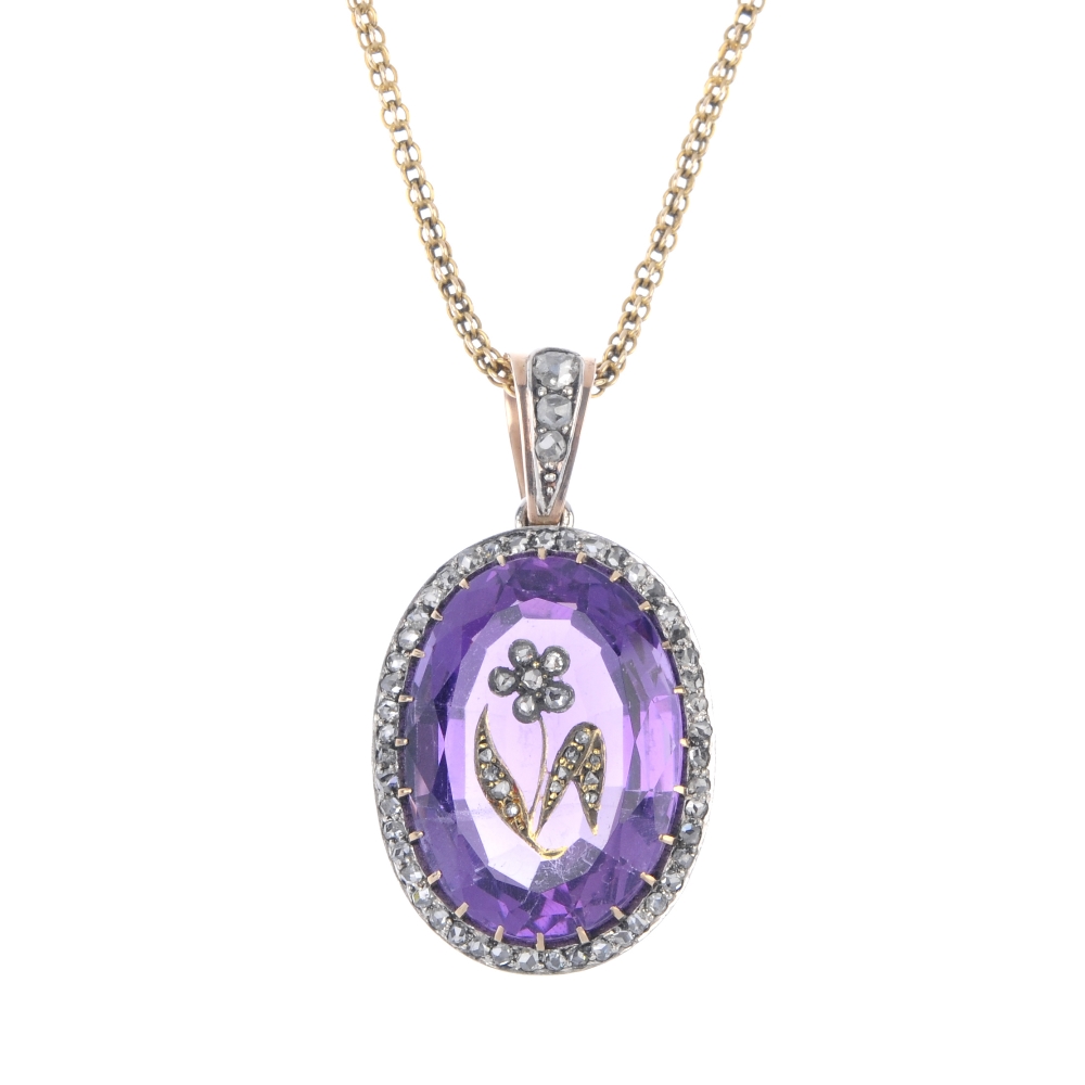 An early 20th century silver and gold, amethyst and diamond pendant. The oval-shape amethyst with