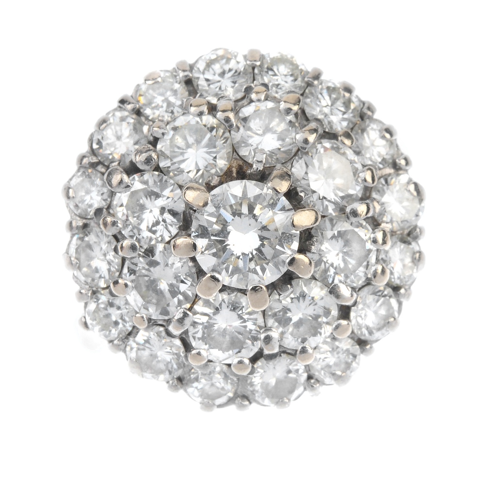 A diamond cluster ring. The brilliant-cut diamond stepped cluster, to the tapered sides and plain