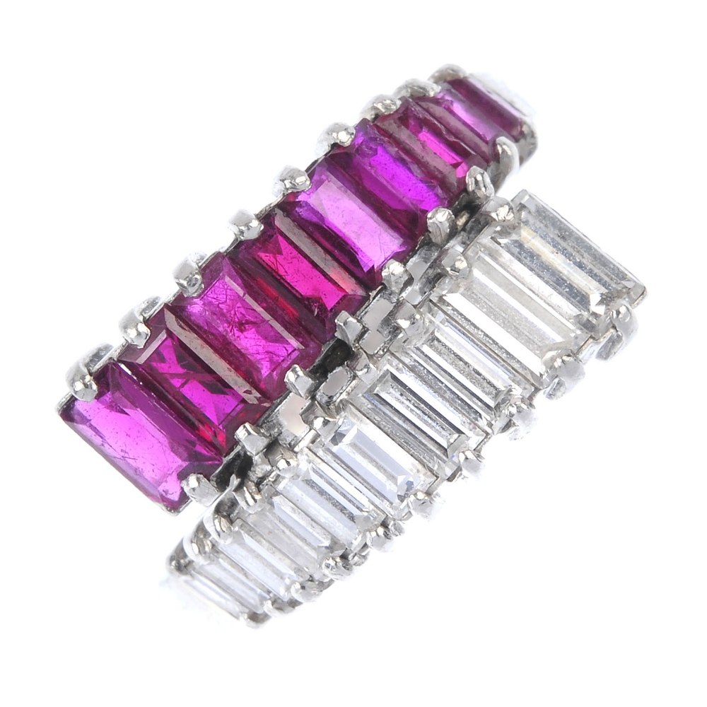 A mid 20th century Burmese ruby and diamond crossover ring. Comprising two graduated baguette-cut