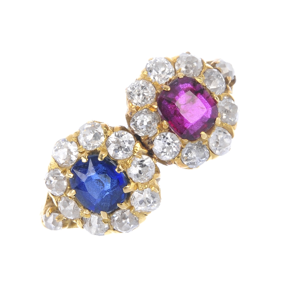 A diamond, sapphire and ruby twin cluster ring. The cushion-shape ruby, within an old-cut diamond