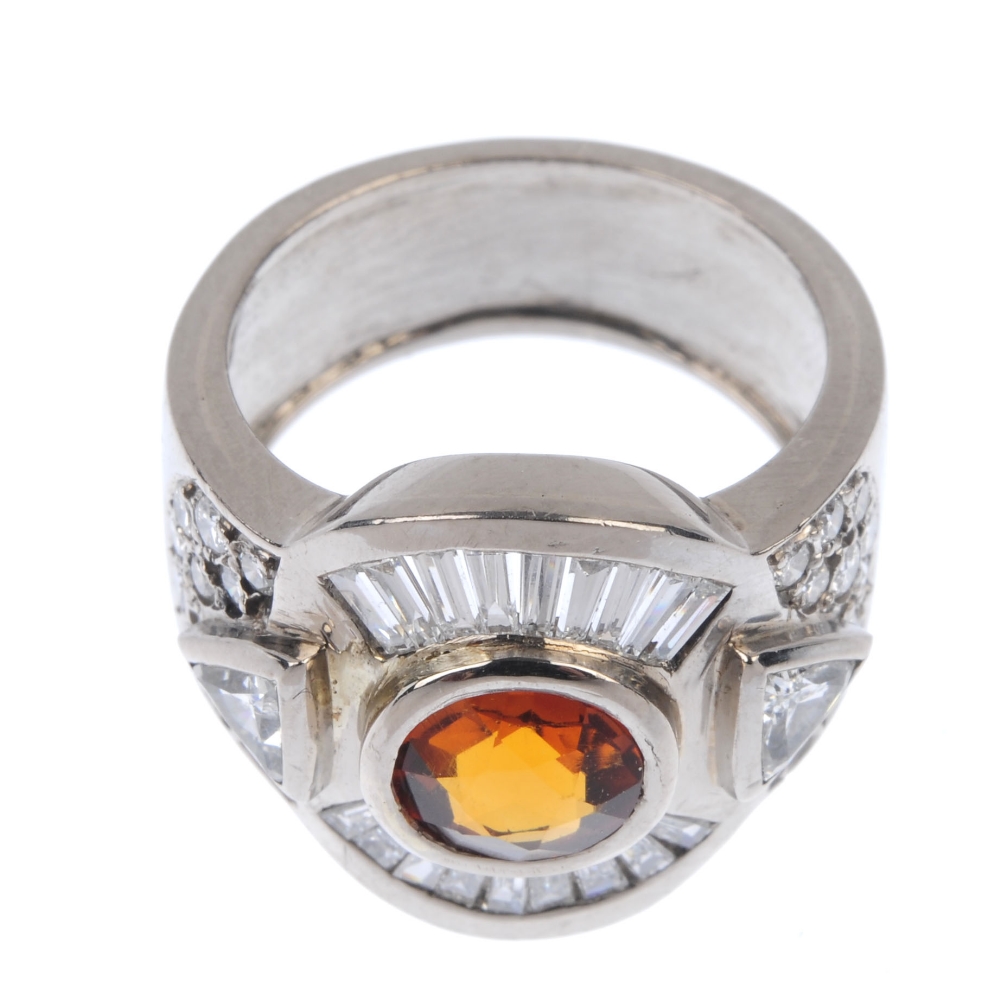 A citrine and diamond dress ring. The circular-shape citrine collet, with tapered baguette-cut and - Image 2 of 4