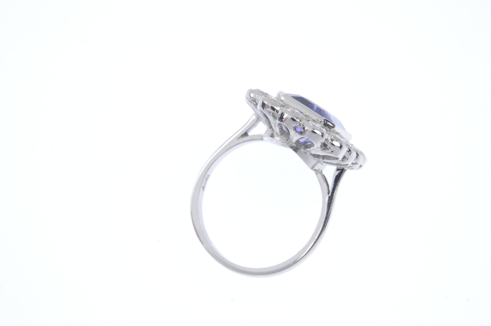 A tanzanite and diamond cluster ring. The rectangular-shape tanzanite collet, within a brilliant-cut - Image 4 of 4