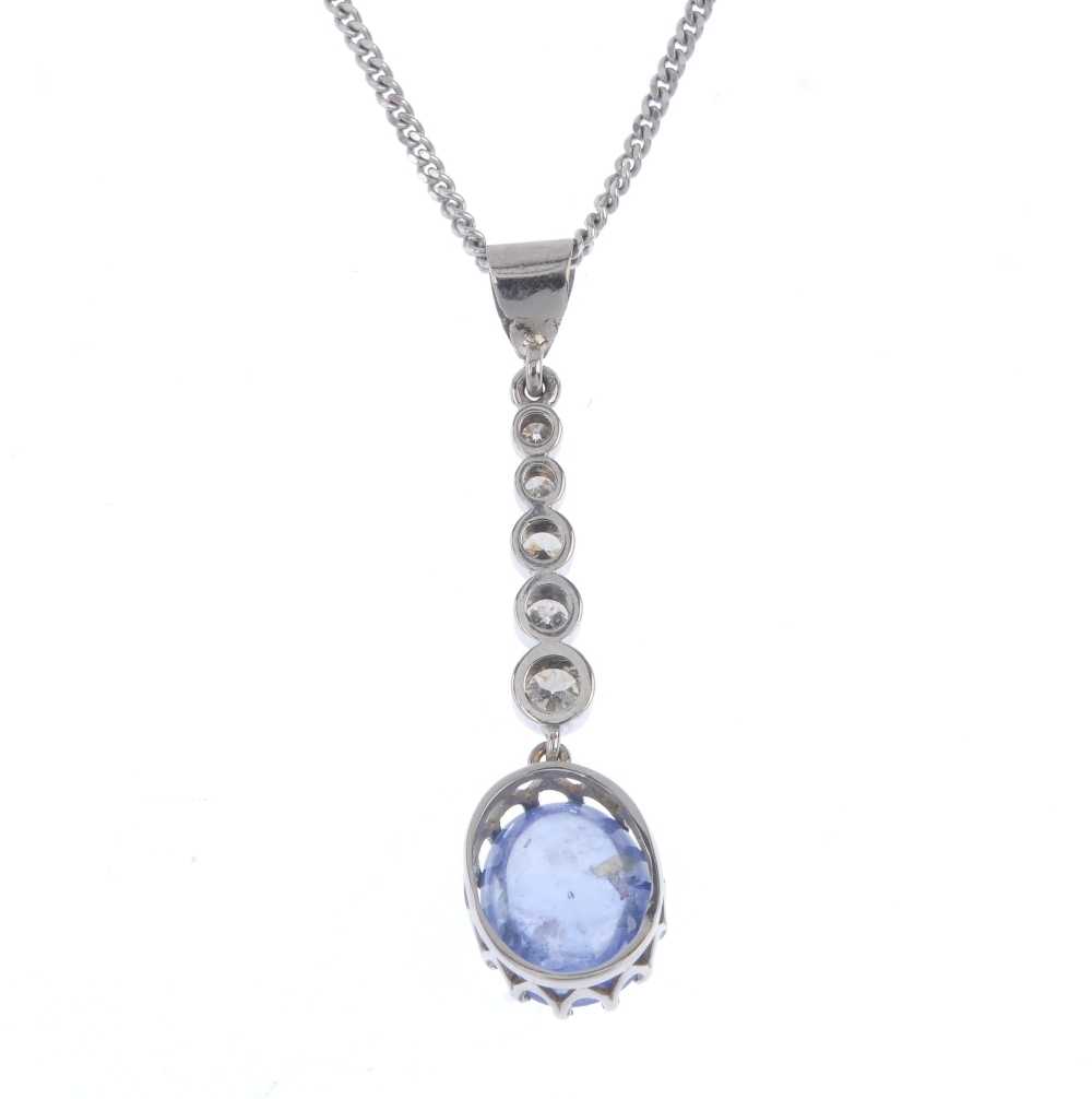 A sapphire and diamond pendant. The oval sapphire cabochon, suspended from a graduated brilliant-cut - Image 2 of 3