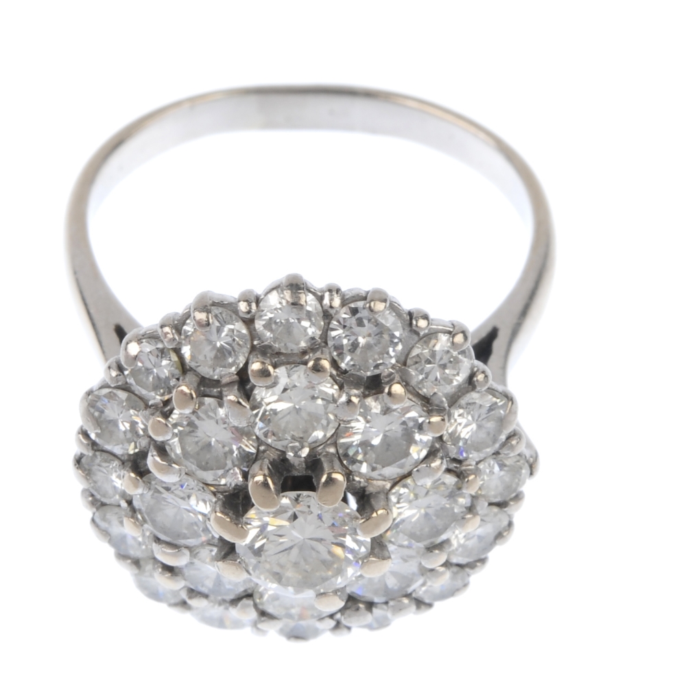 A diamond cluster ring. The brilliant-cut diamond stepped cluster, to the tapered sides and plain - Image 2 of 4