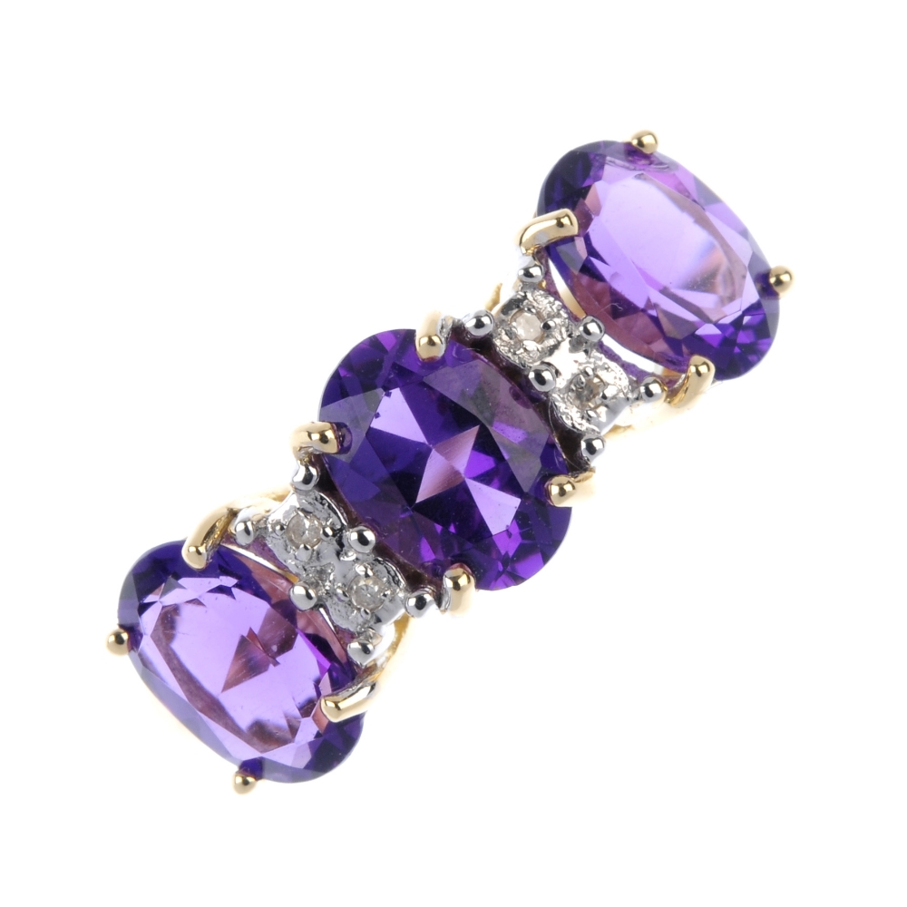 An 18ct gold amethyst and diamond ring. The oval-shape amethyst line, between single-cut diamond