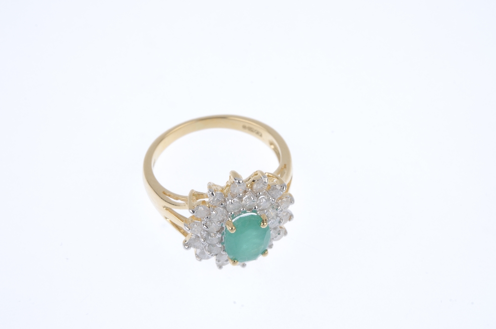 An 18ct gold emerald and diamond cluster ring. The oval-shape emerald, within a brilliant-cut - Image 2 of 4