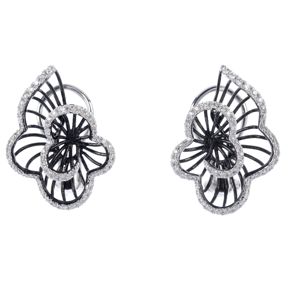 A pair of 18ct gold diamond floral earrings. Each designed as a graduated brilliant-cut diamond