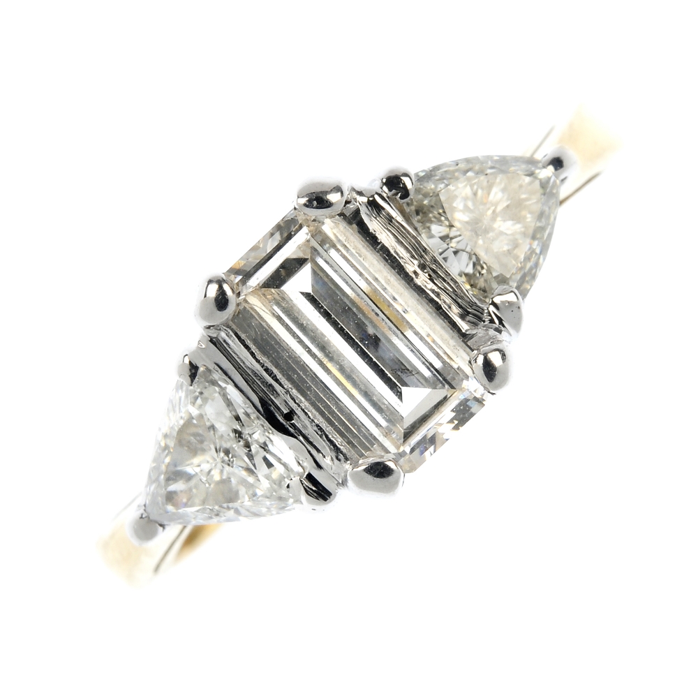 An 18ct gold diamond three-stone ring. The rectangular-shape diamond, to the triangular-shape