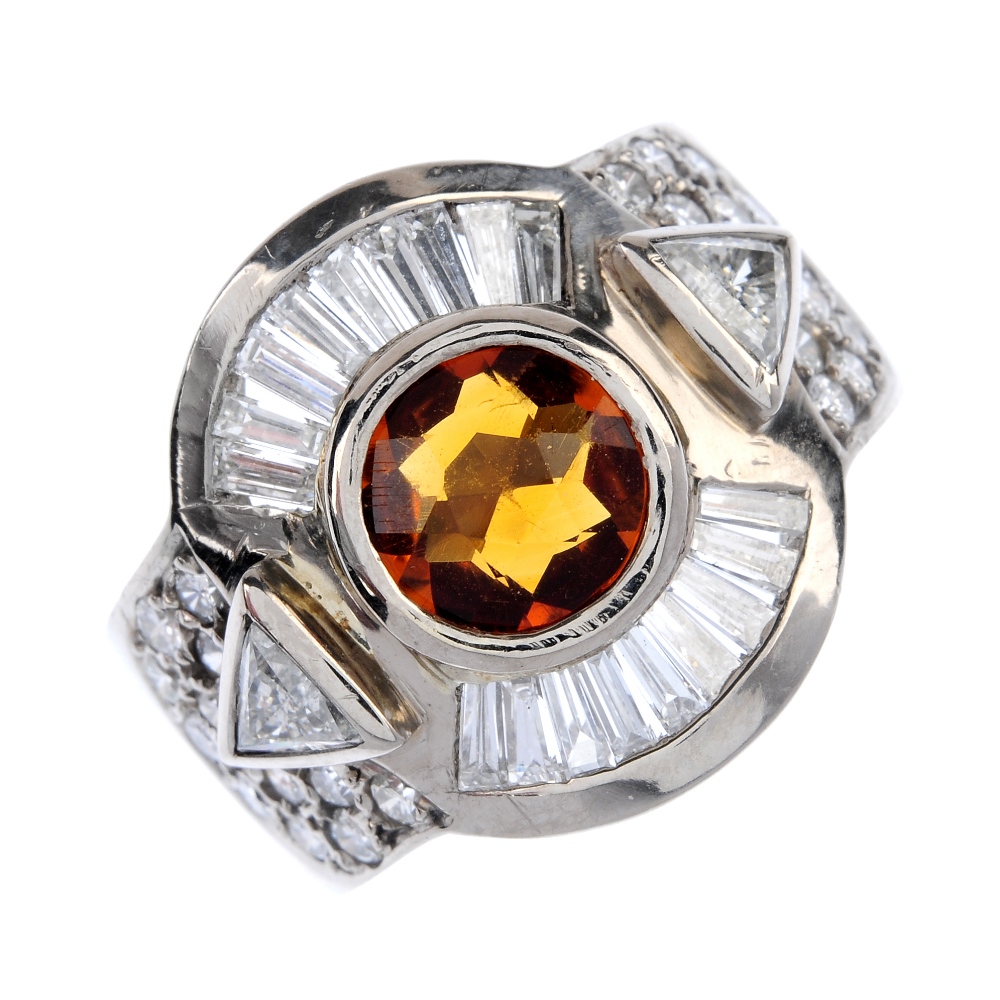 A citrine and diamond dress ring. The circular-shape citrine collet, with tapered baguette-cut and