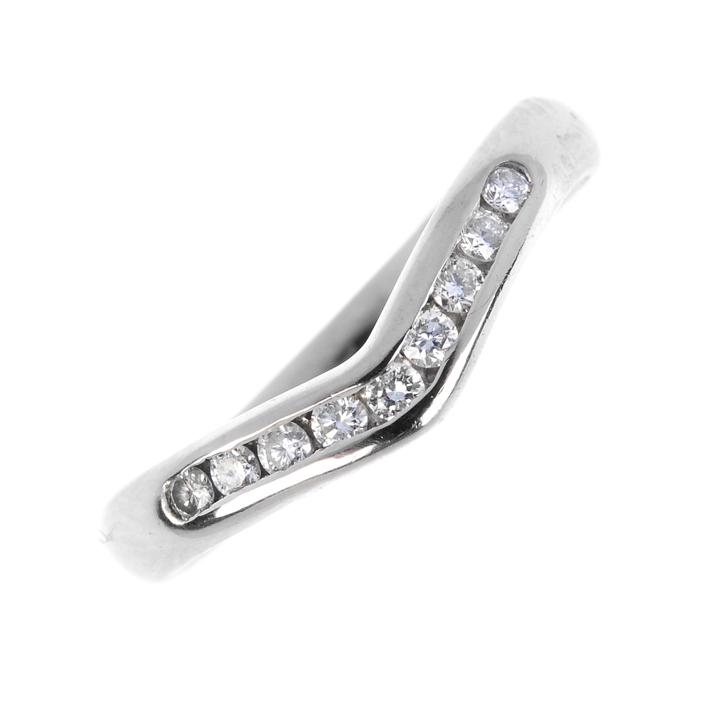 A platinum diamond ring. The brilliant-cut diamond chevron, within a channel setting, to the plain