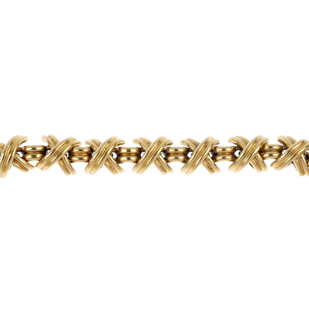 TIFFANY & CO. - a 'Kisses' bracelet. Designed as a series of crossed bars, interspaced by grooved