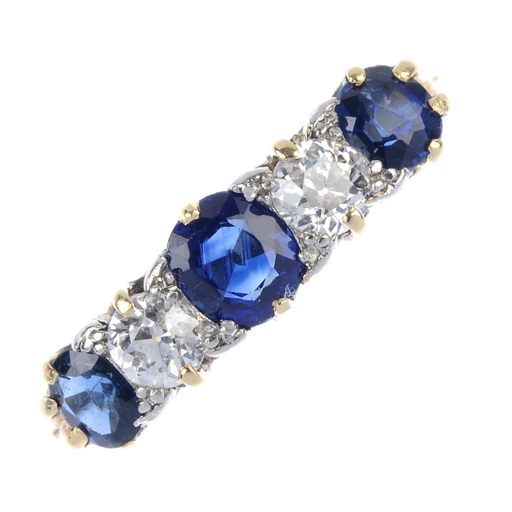 A sapphire and diamond ring. The graduated oval-shape sapphire line, with old-cut diamond spacers,