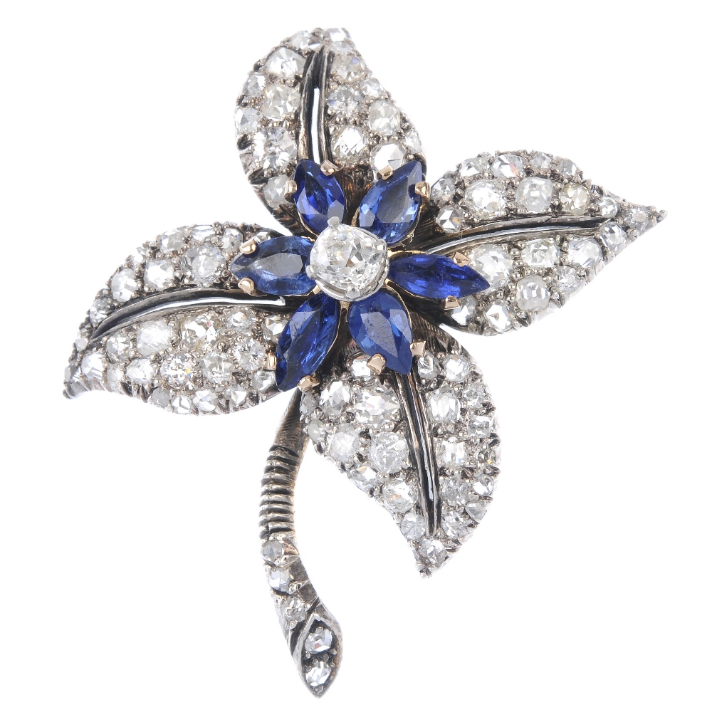 An early 20th century gold diamond and sapphire floral brooch. The old-cut diamond, within a pear-