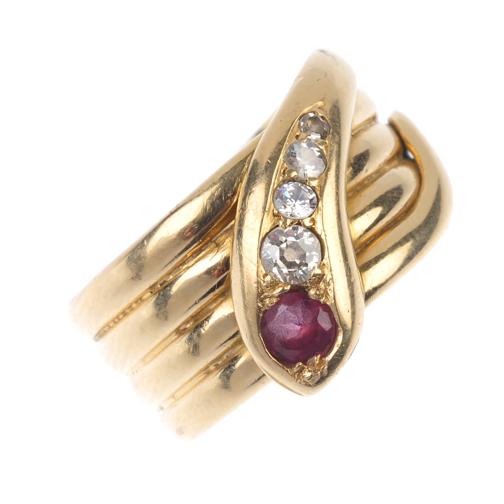 An early 20th century 18ct gold garnet and diamond snake ring. Designed as a coiled serpent, the